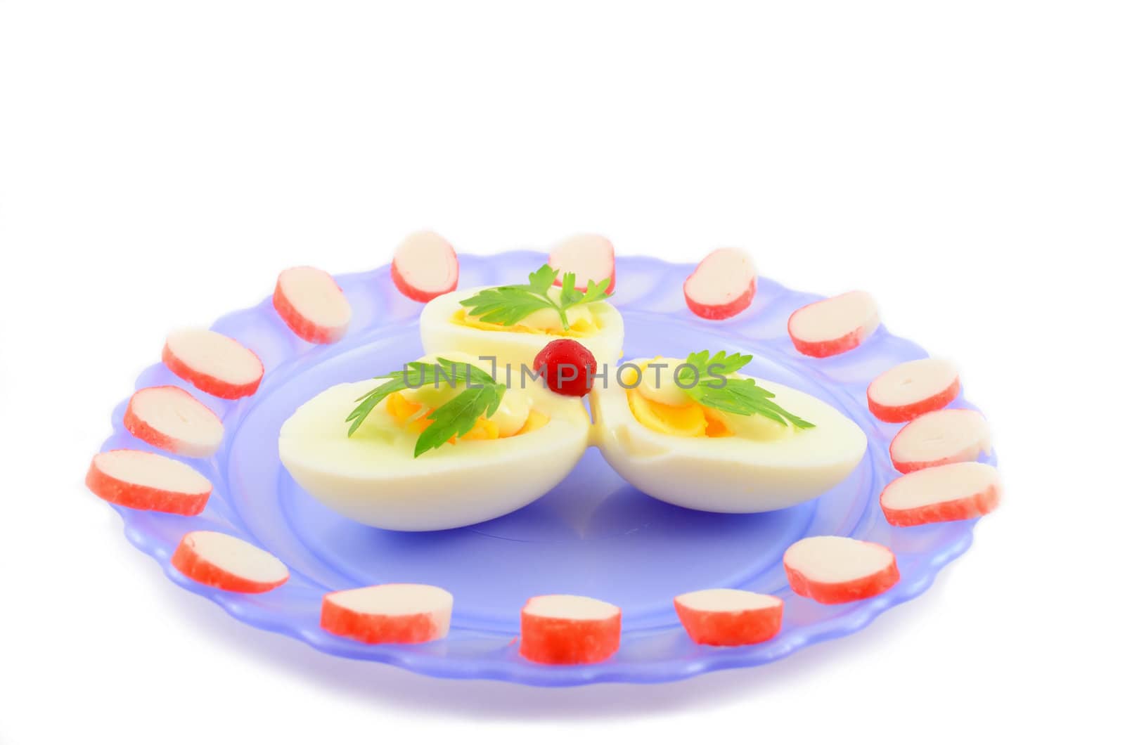 Cooked boiled eggs with sauce, decorated with parsley, cranberries and crab sticks