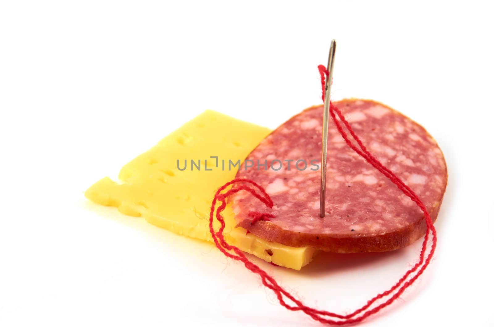 A piece of smoked sausage sewn to a firm cheese 