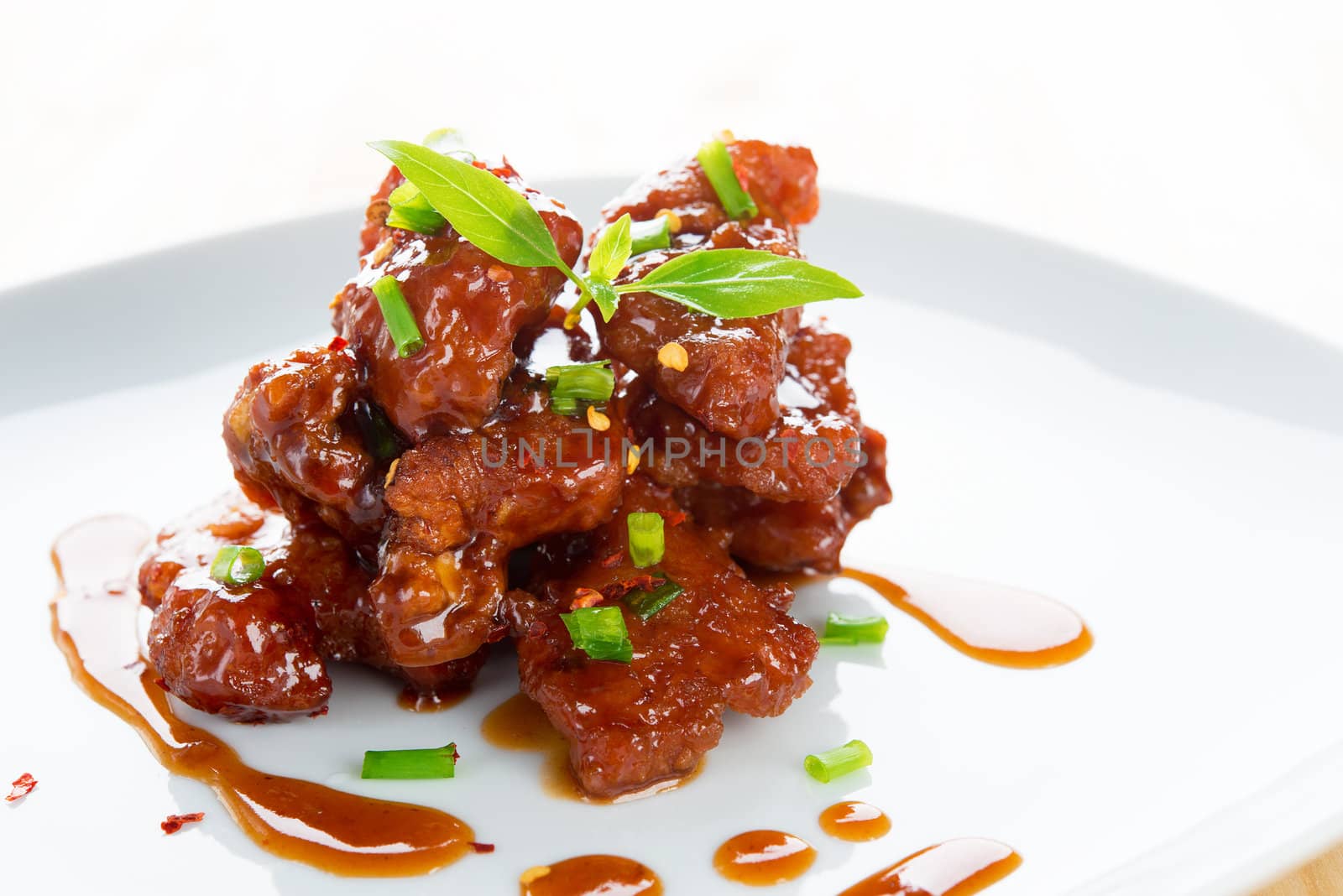 Chinese spare ribs on a plate isolated on white.