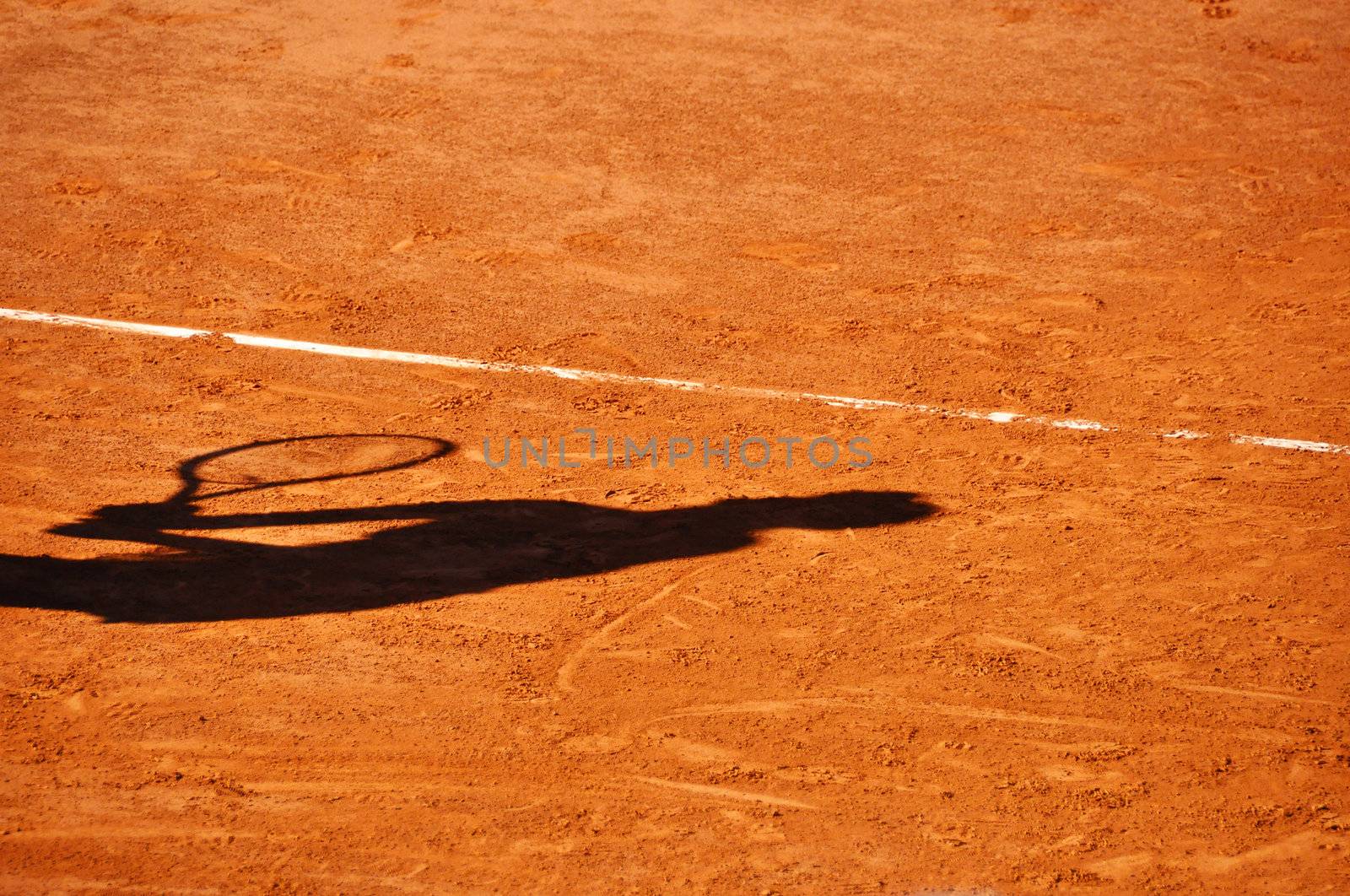 Tennis player shadow on a clay tennis court