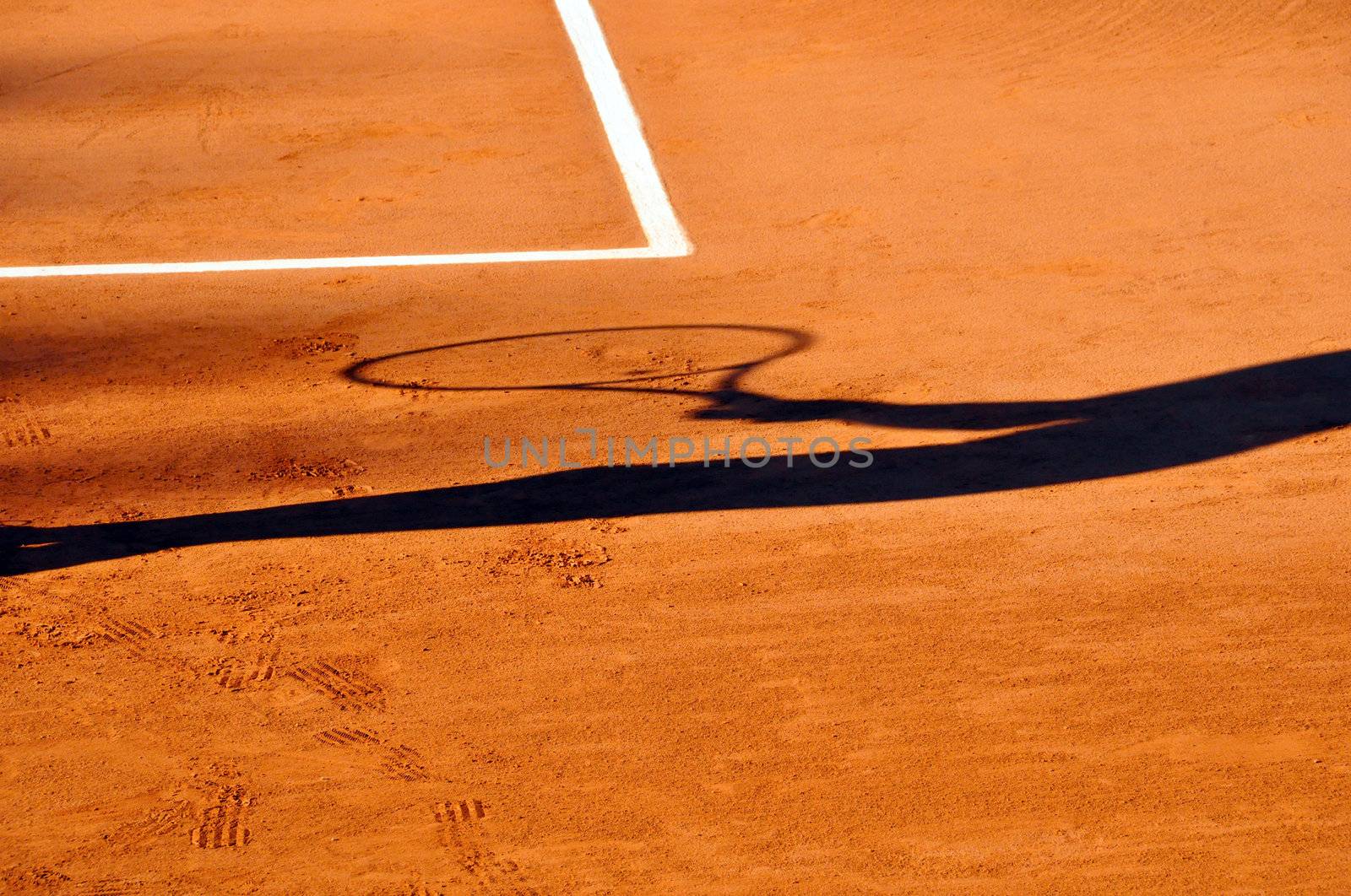 Tennis player shadow on a clay tennis court