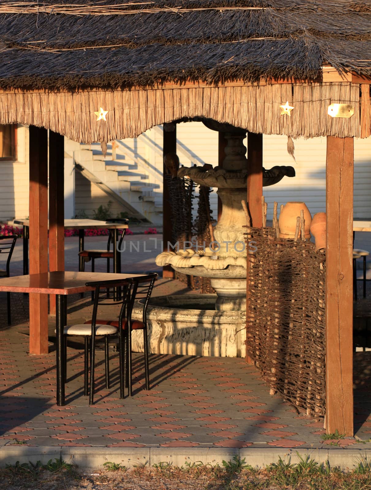 Tables and a fountain in summer cafe ethno under cover of reeds