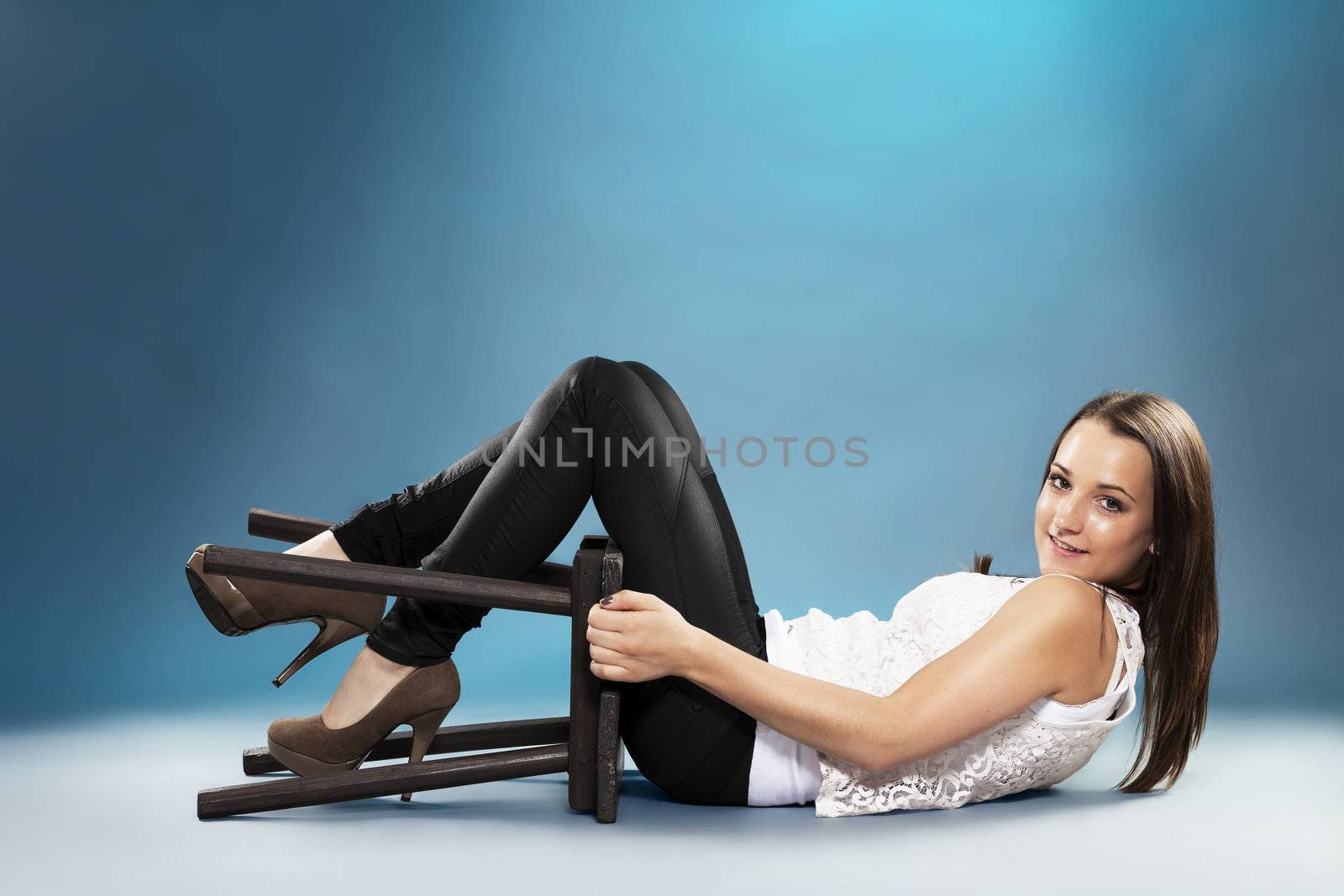 teenager with a chair lying on the floor with blue lights