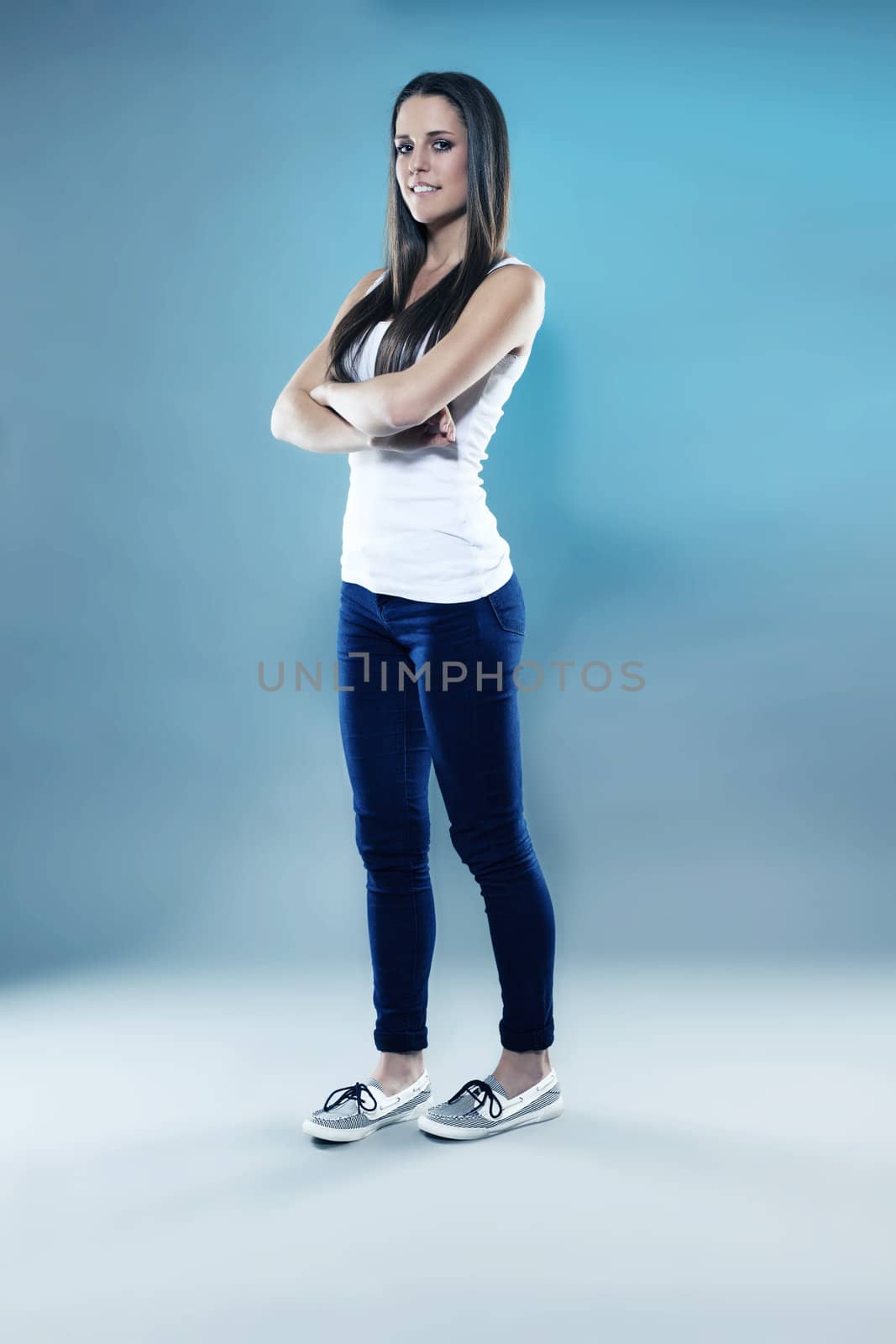 pretty sporty teenager with crossed arms in blue light