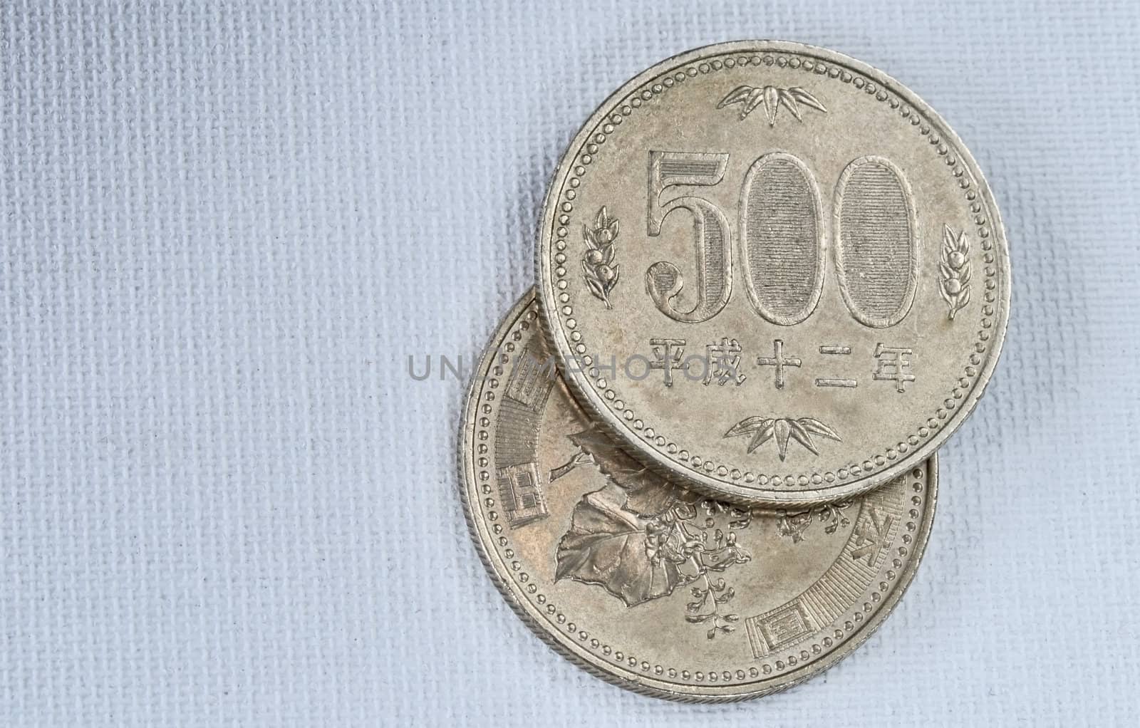 Five hundred Yen coins on japanese paper background. Macro image.