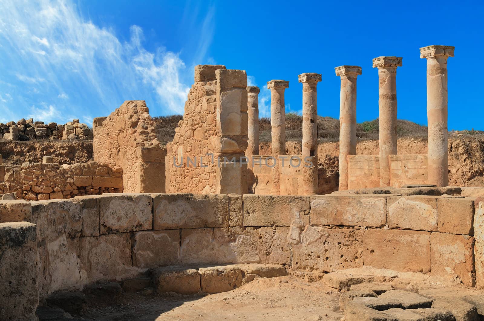 Ancient Greek columns in the ruins against a blue sky.