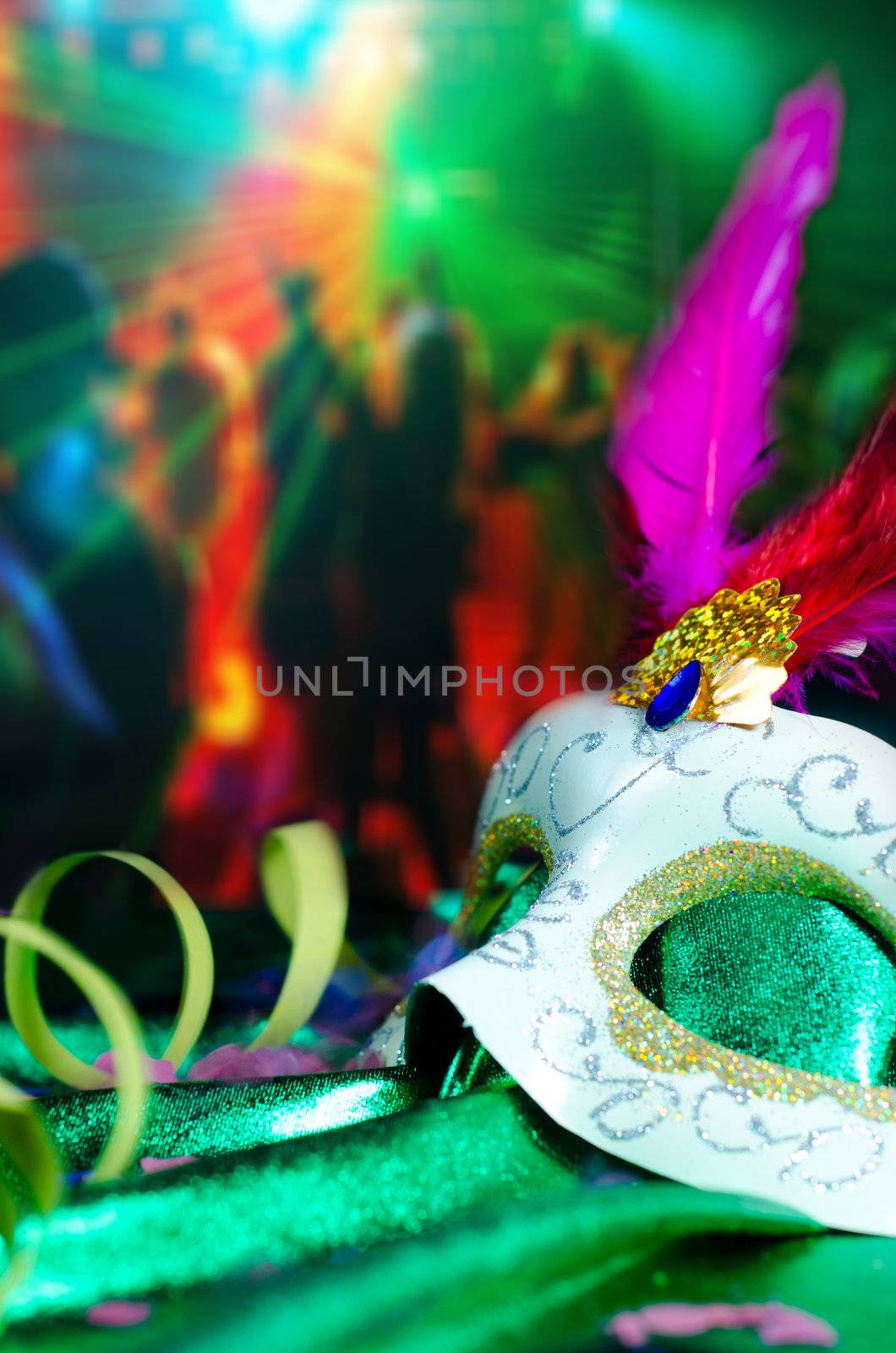 Carnival mask on the table with a great party going in the background with people dancing.