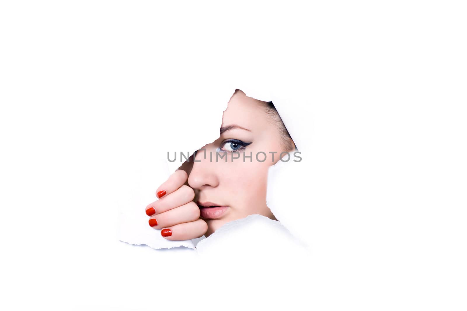 Young girl looking through hole in white paper