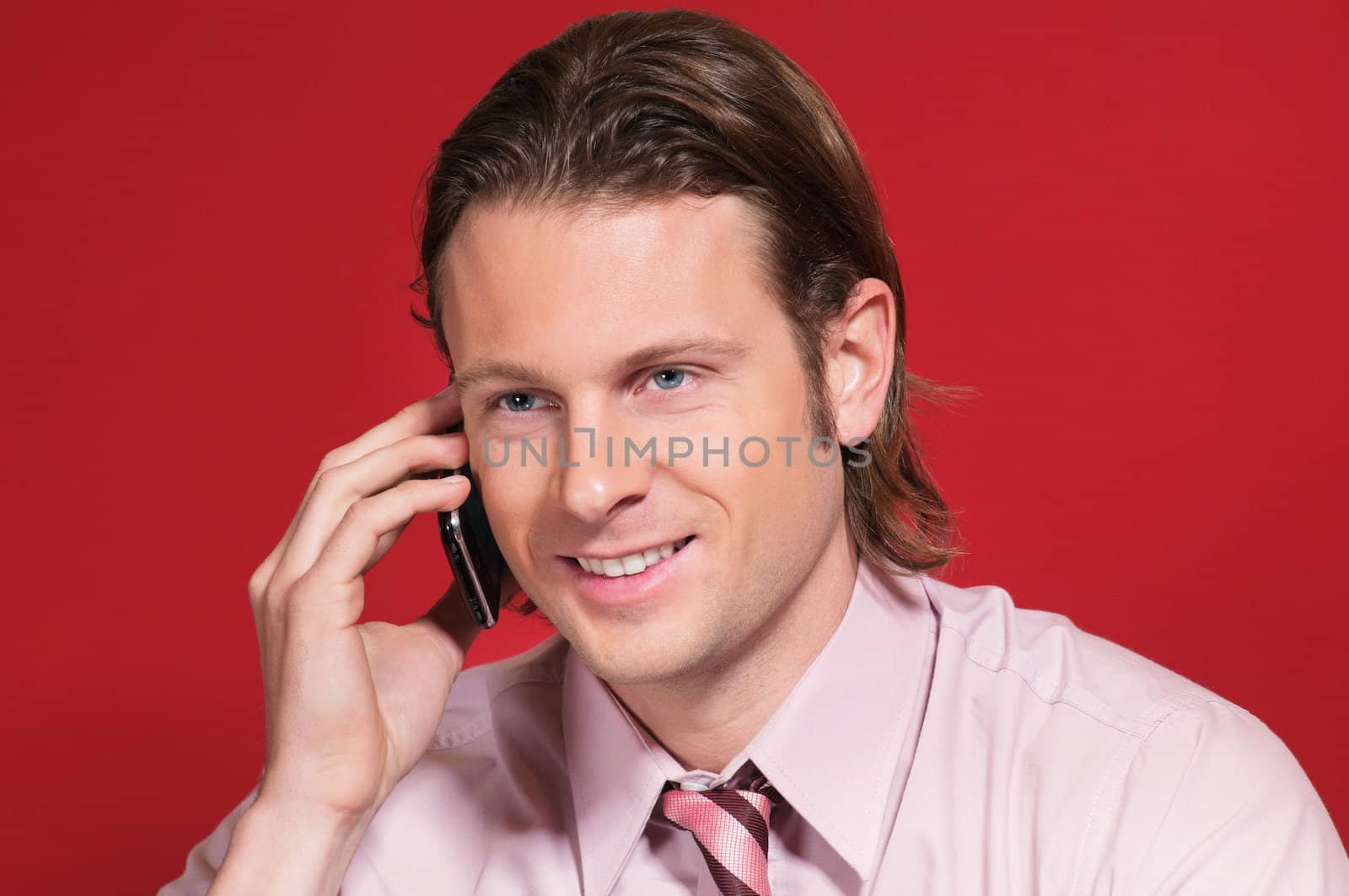 Businessman talking on a cell phone by leaf