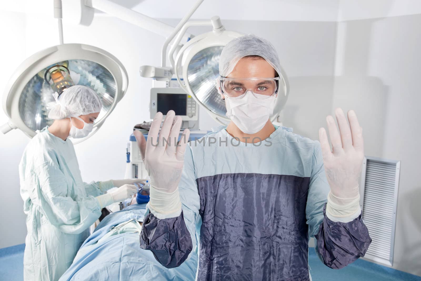 Male surgeon asking for gloves by leaf