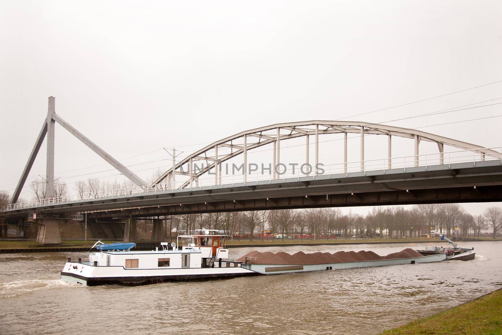 ship transporting sand under bridge in holland by ahavelaar