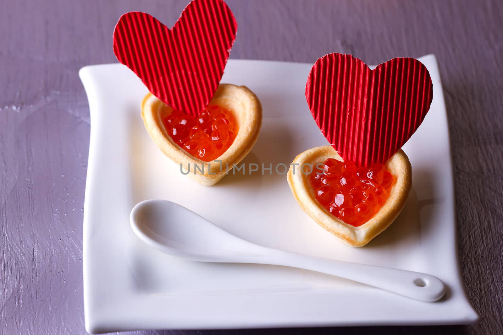 Tartlets with red caviar and paper hearts on Valentine's Day