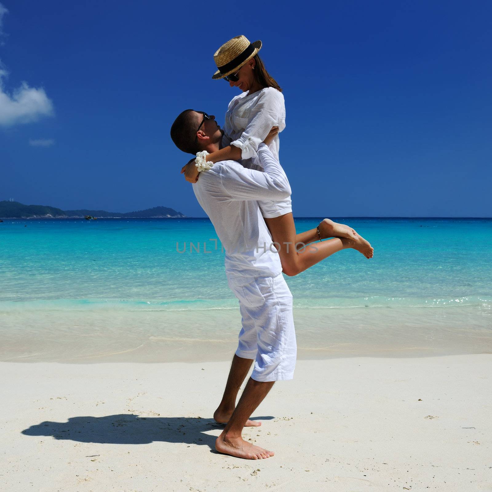 Couple in white on a beach by haveseen