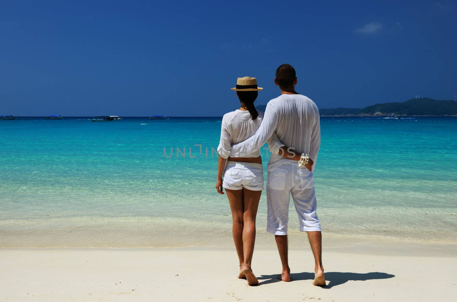 Couple in white on a beach by haveseen