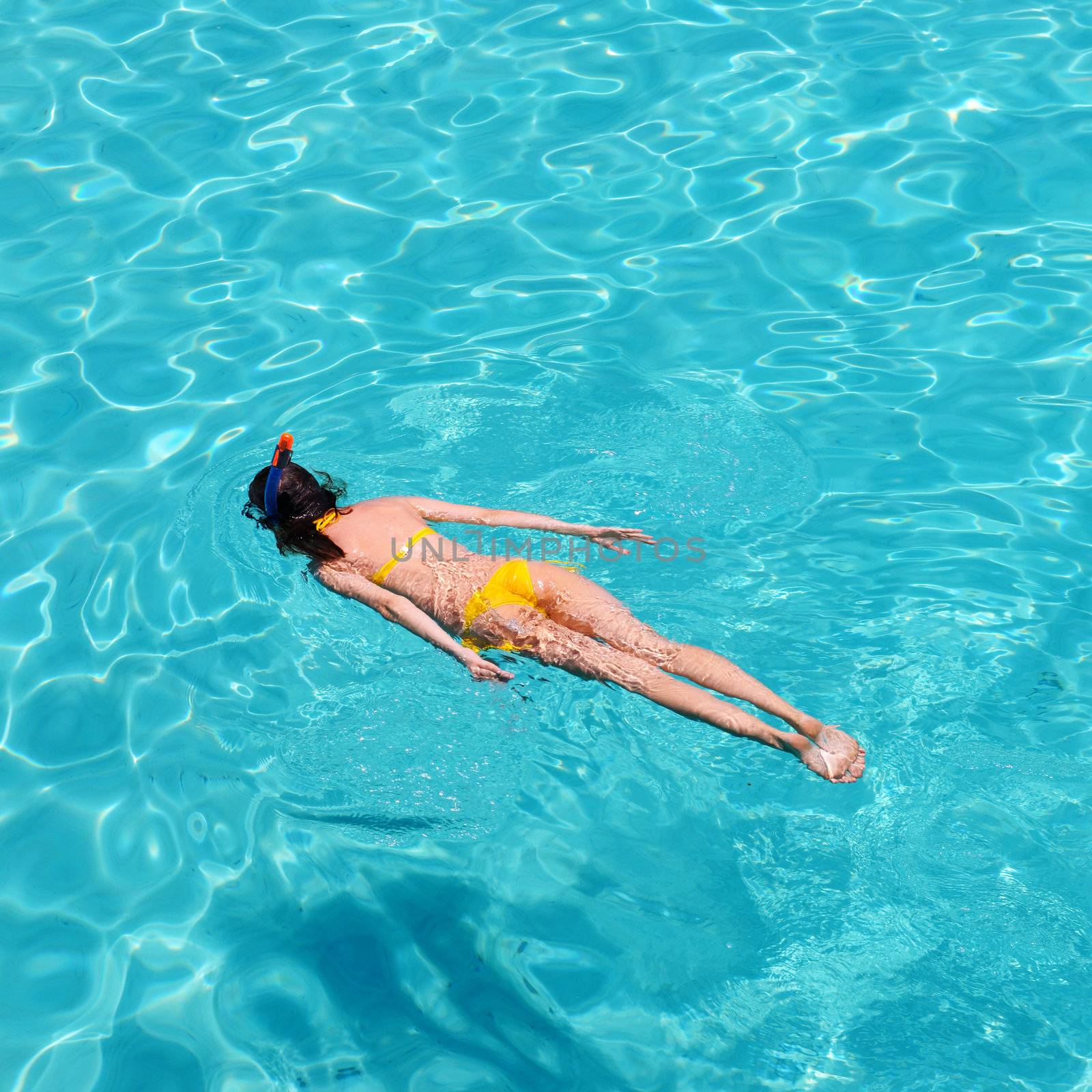 Woman snorkeling in crystal clear turquoise water at tropical beach