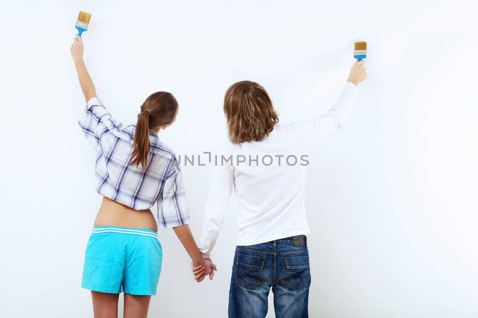 Portrait of young couple with paint brushes