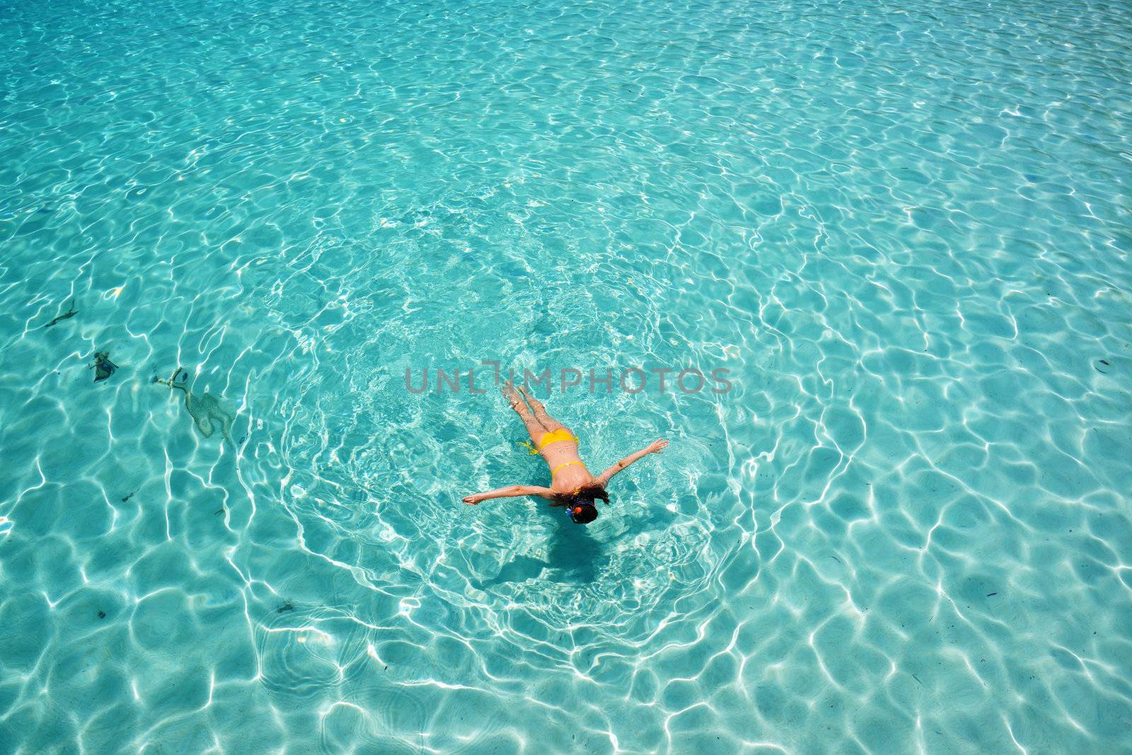 Woman snorkeling in crystal clear turquoise water at tropical beach