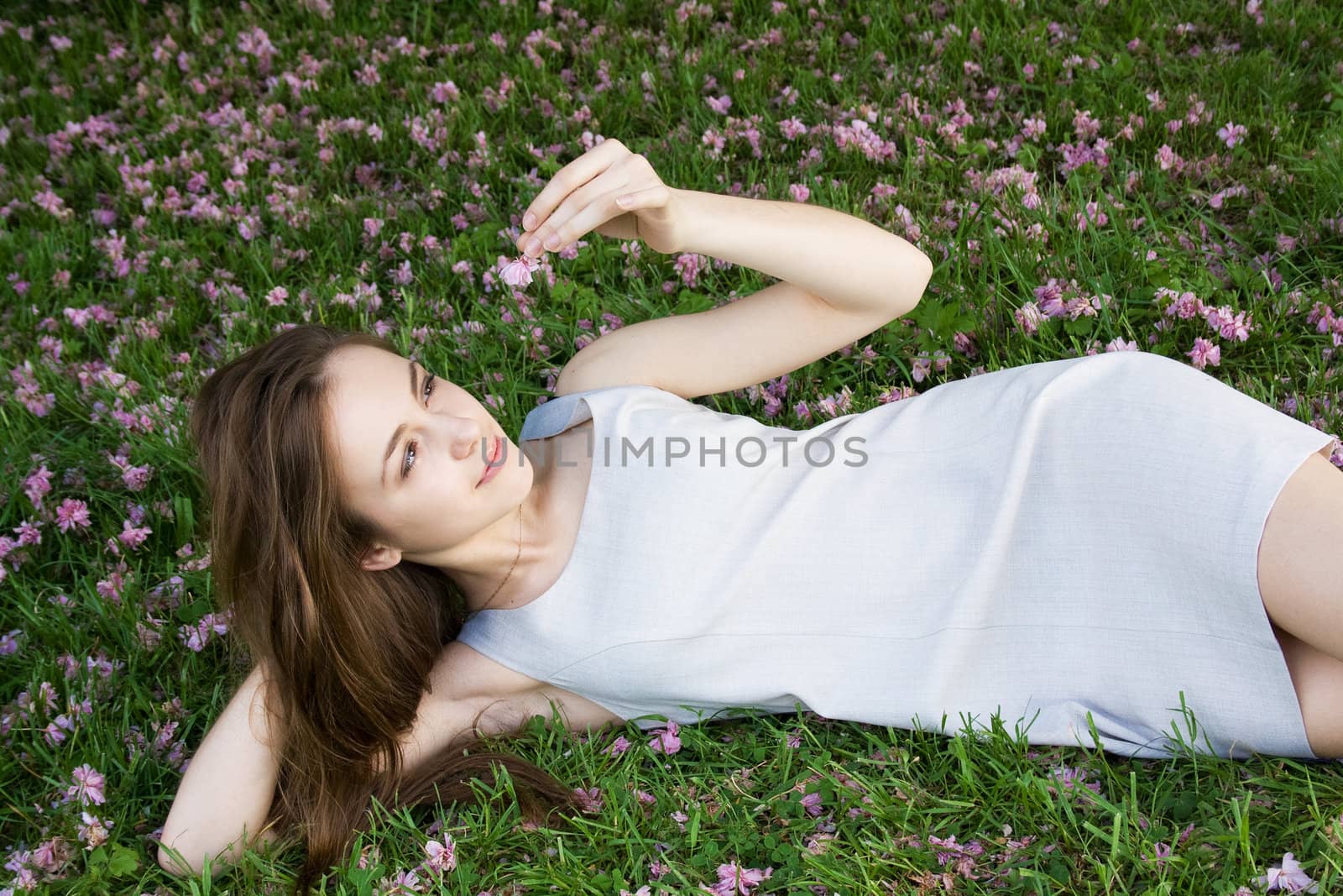 Happy young woman lying on green grass