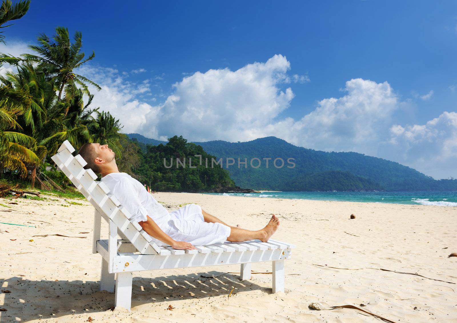Man relaxing on a beach by haveseen