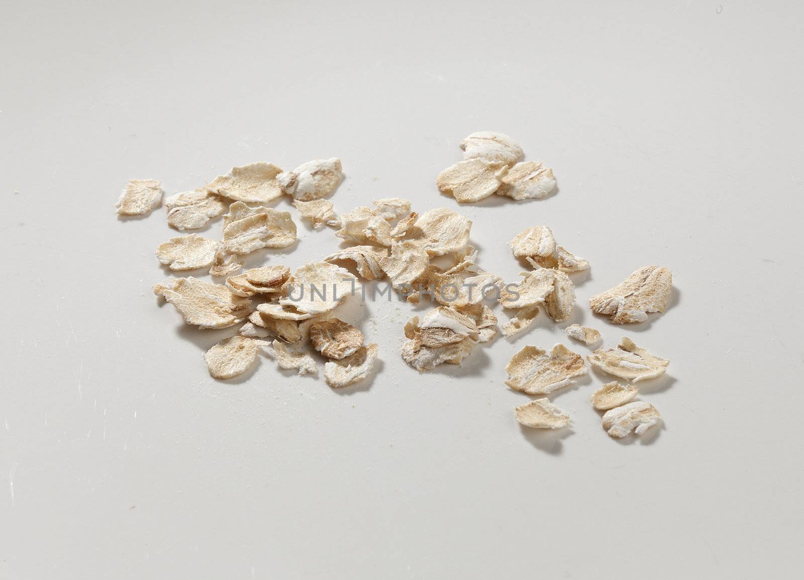 Handful of oat flakes on the grey background