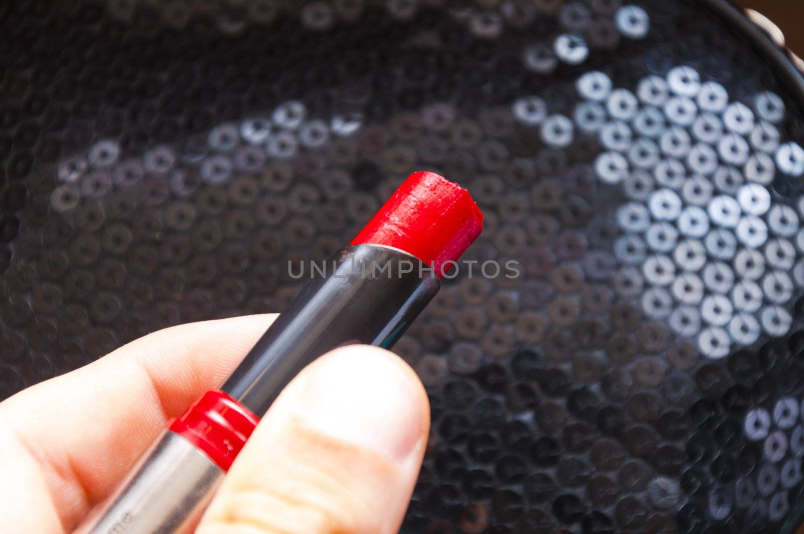 An image of red lipstick in hand