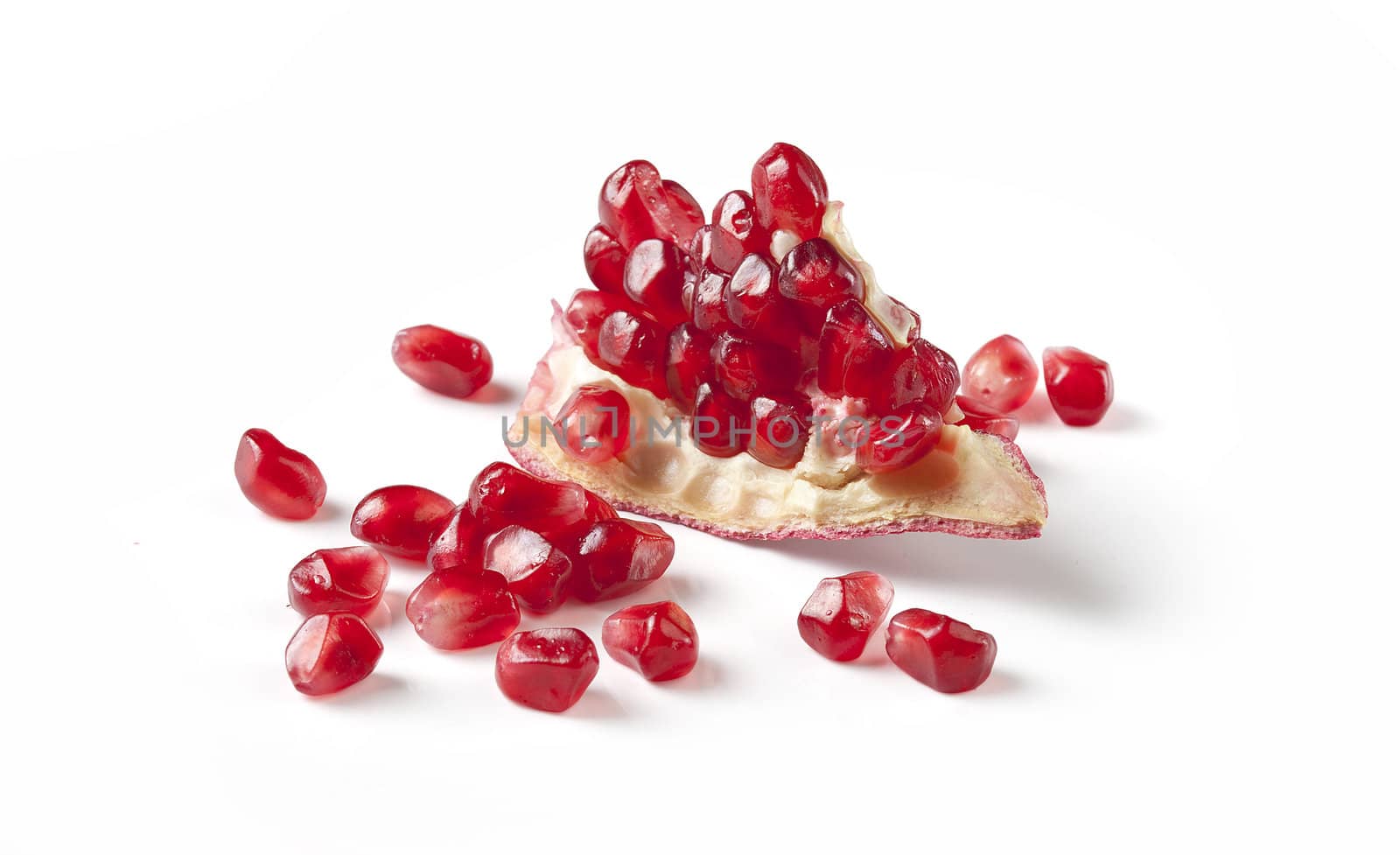 Fresh red piece of pomegranate with seeds on the white