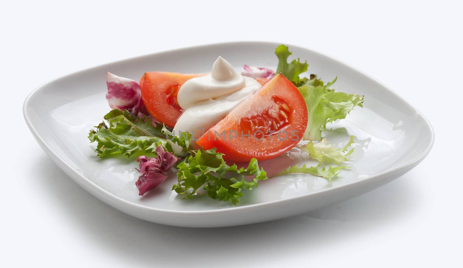 Two pieces of tomato with lettuce and mayonnaise