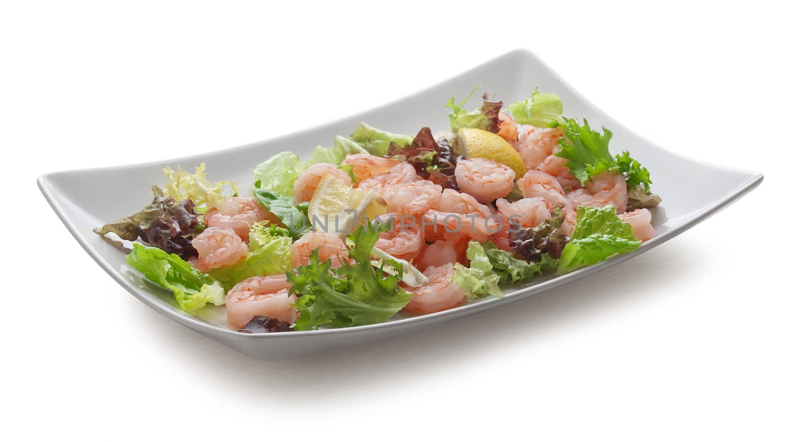 Shrimps with lettuce and lemon on the white plate