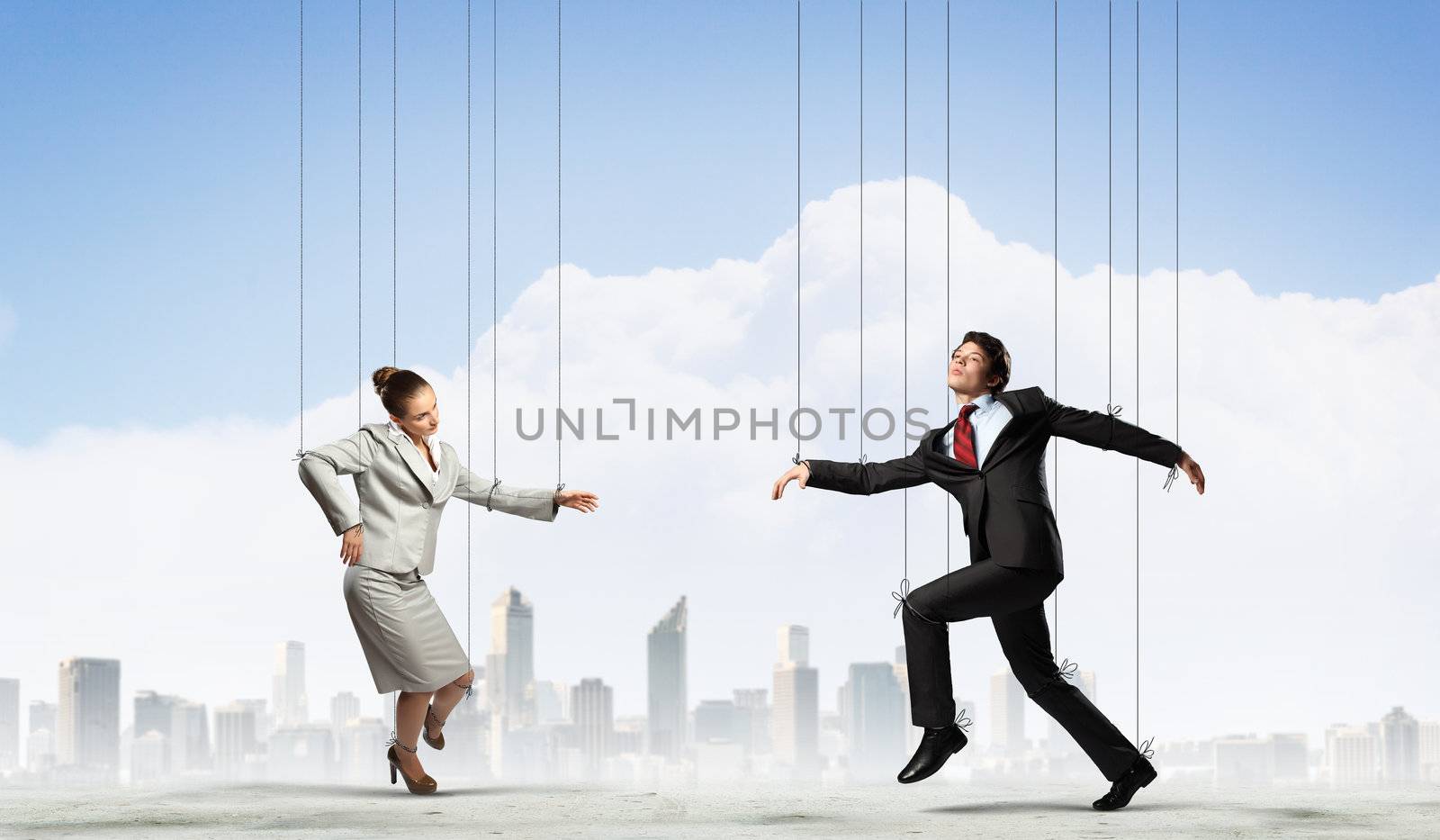 Image of businesspeople hanging on strings like marionettes against city background. Conceptual photography
