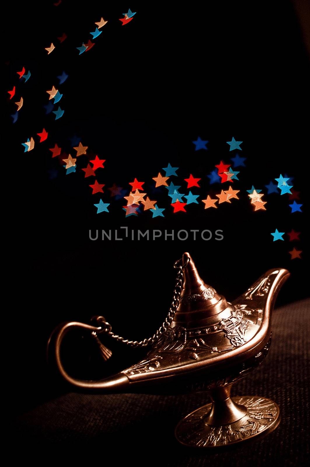 the lamp of Aladdin with stars light on a black background