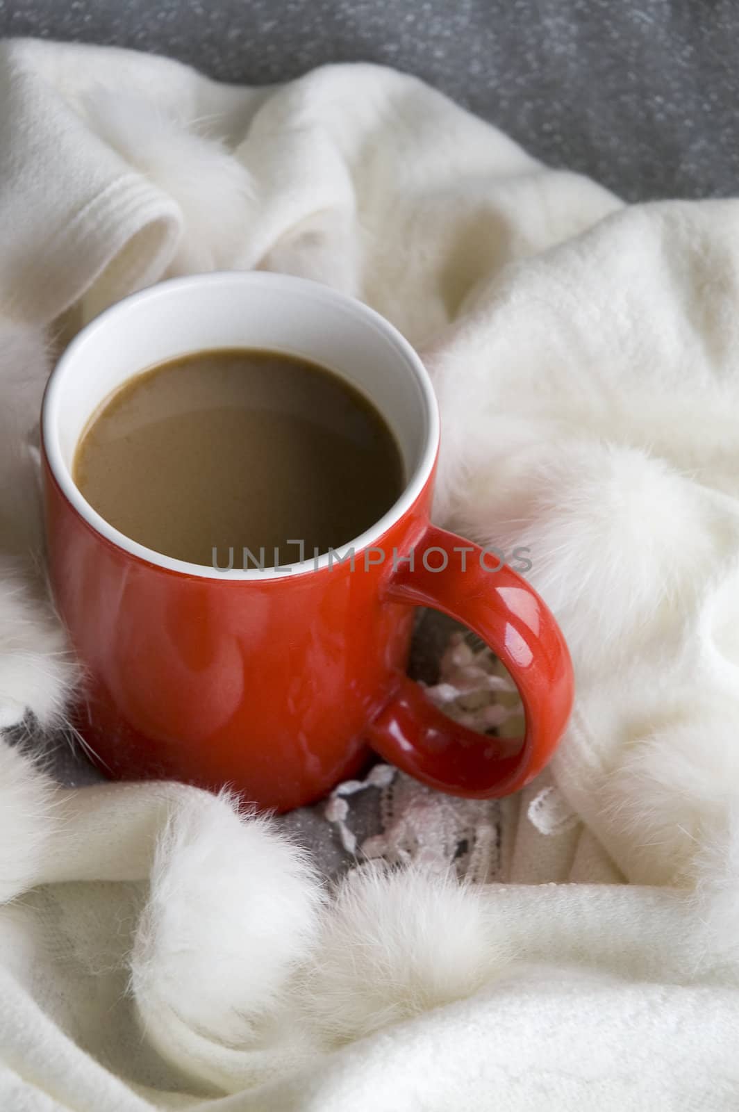 hot coffee in red cup with white wool scarf around