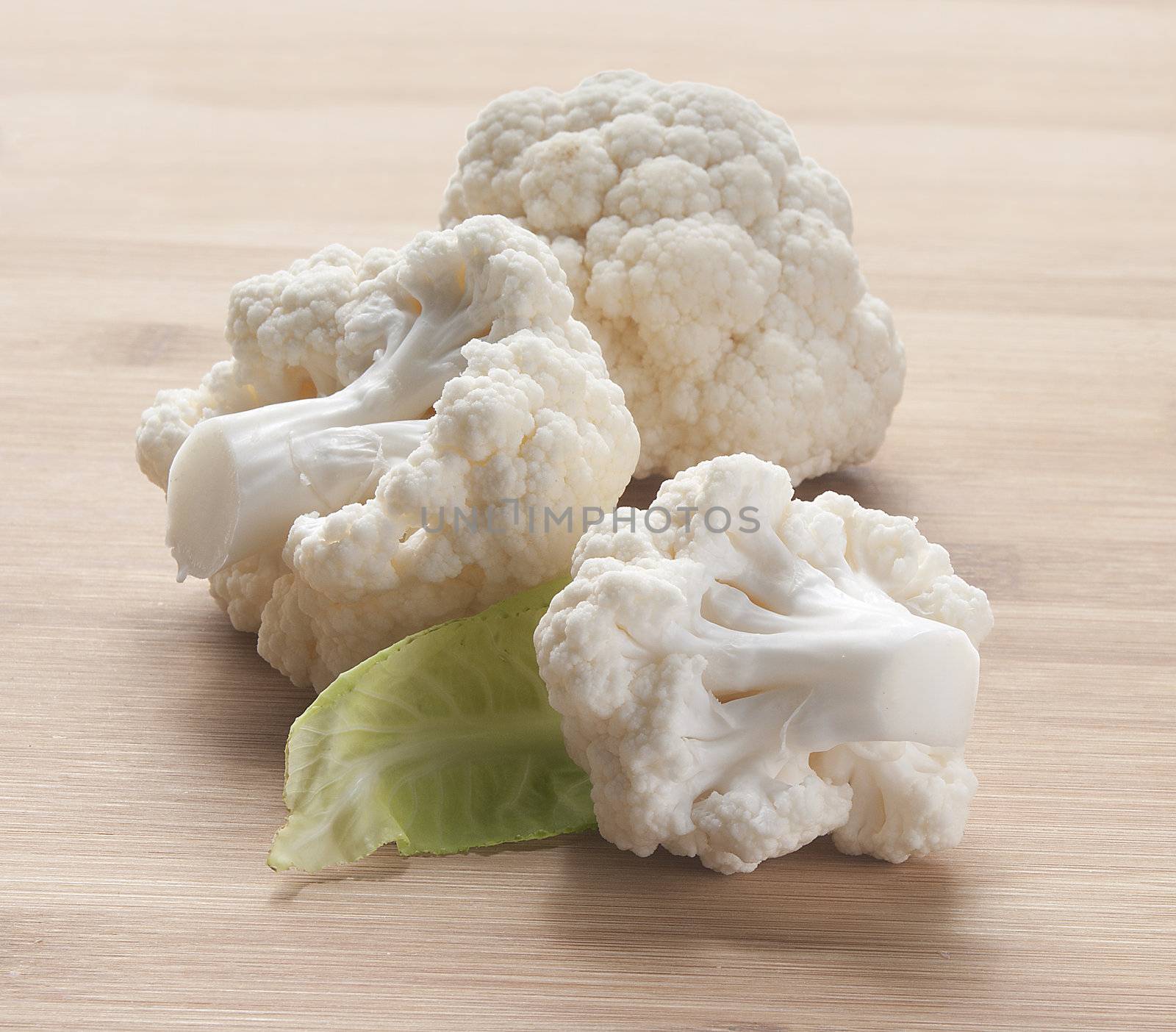 Some branches of cauliflower with leaf on the wooden board