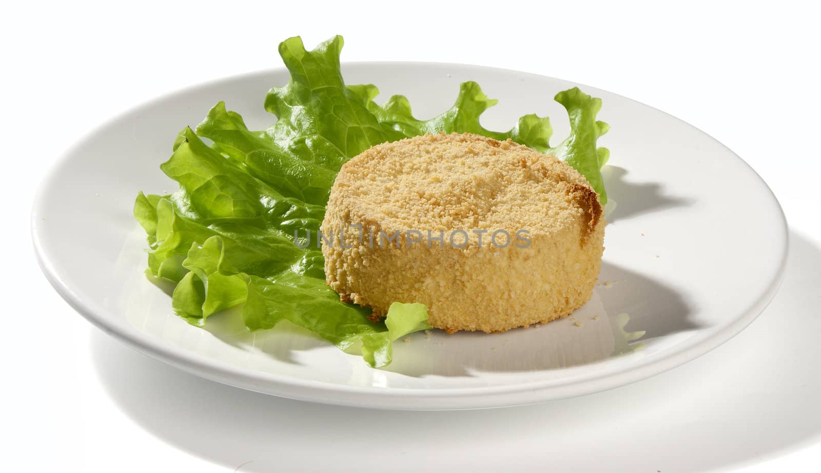 Baked camambert coated with breadcrumbs with lettuce on the plate