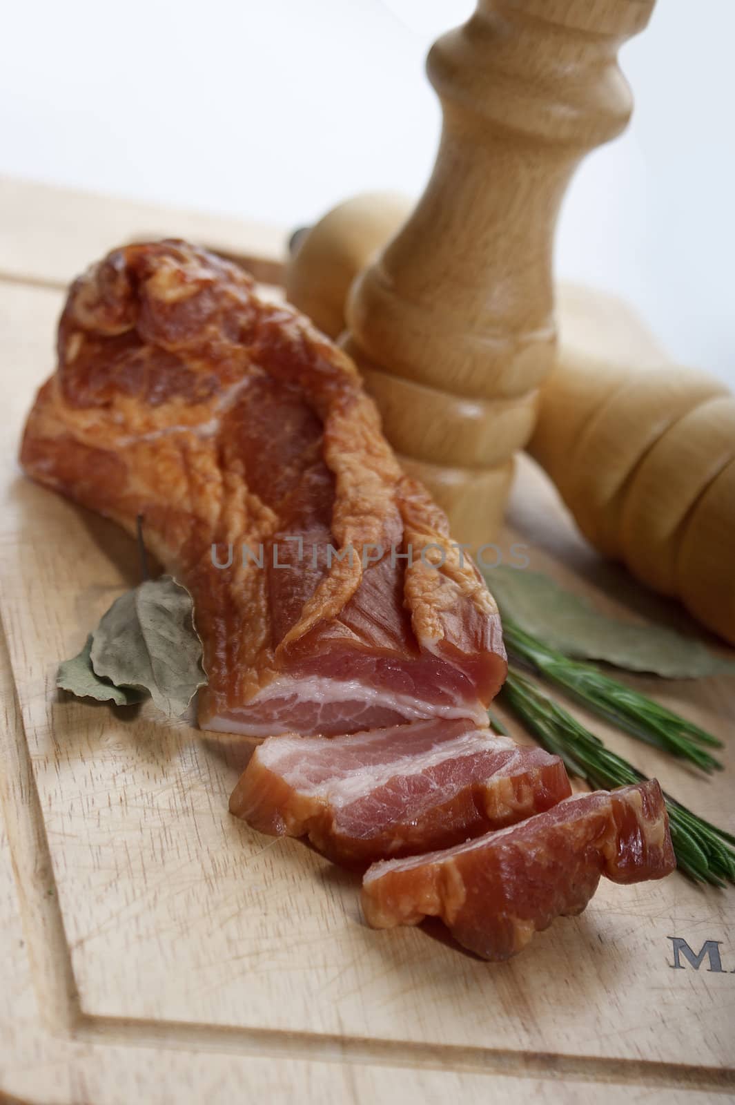 Pieces of bacon with herbs on the wooden board