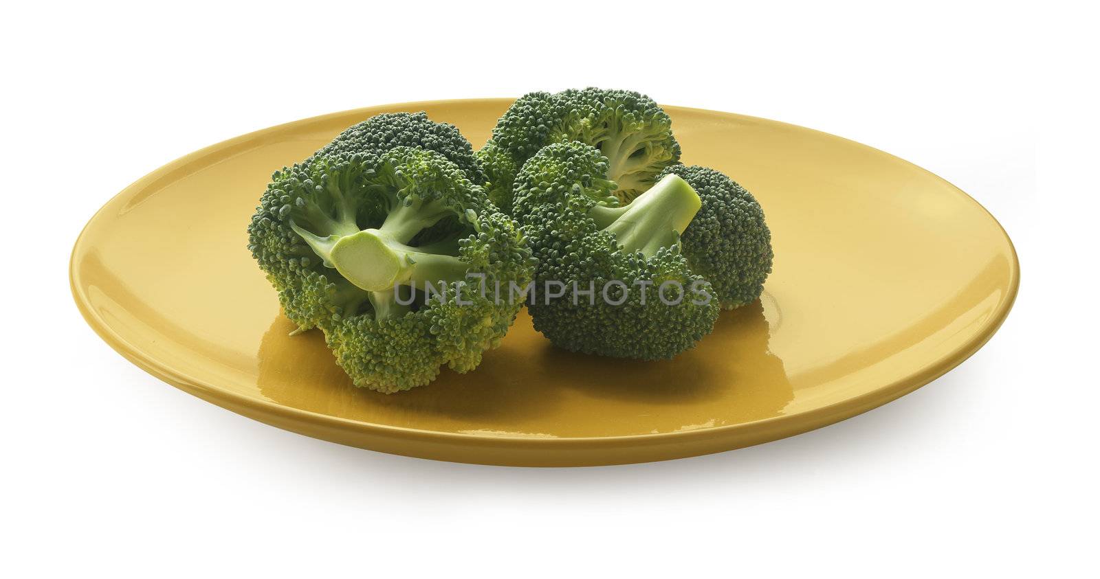 Some pieces of broccoli on the yellow plate