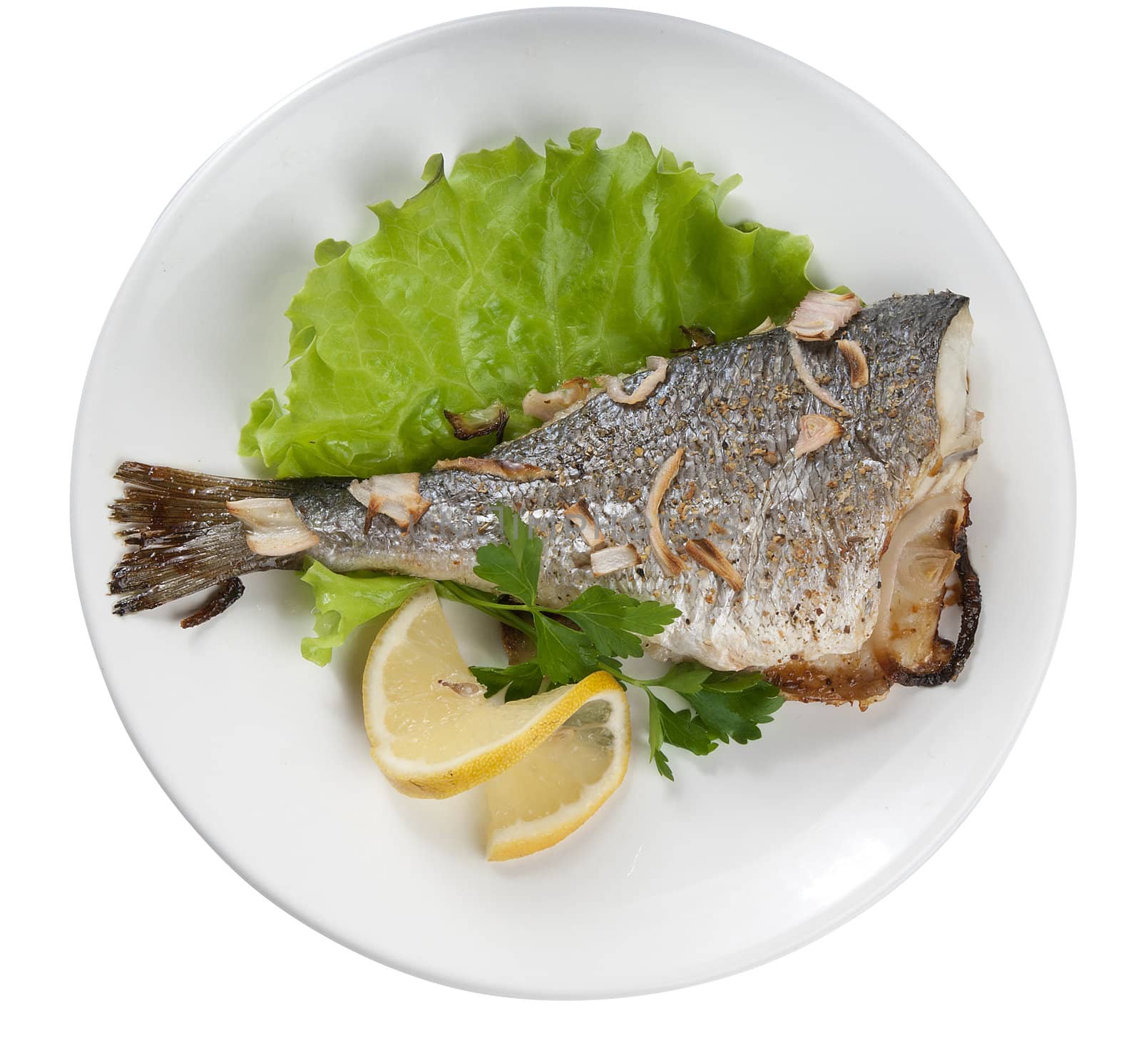 Baked sea bream with lettuce and lemon on the white plate