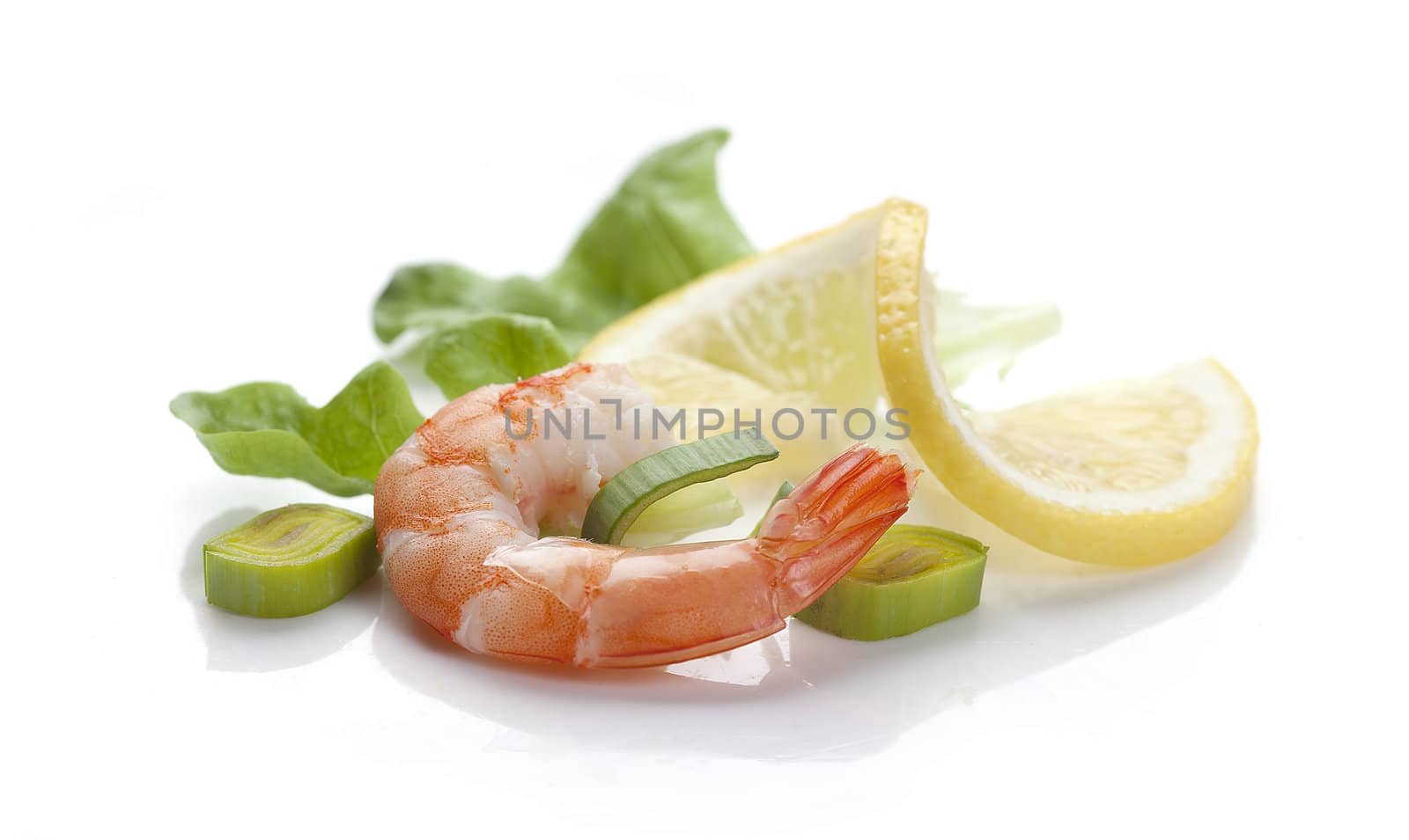One boiled shrimp's tail with  lettuce, leek and lemon on the white