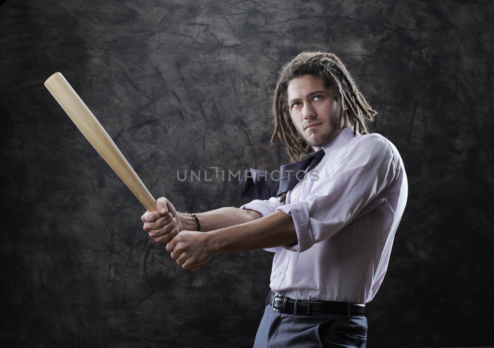 Young businessman swinging baseball bat