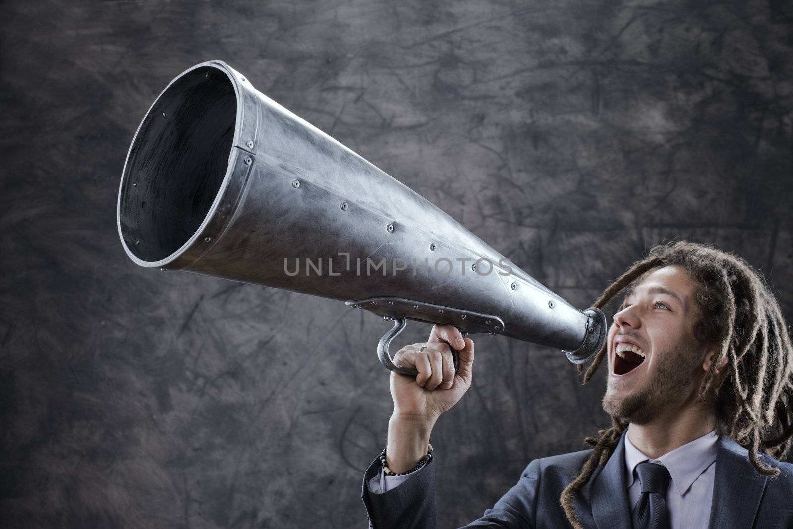 Young businessman yelling trough a vintage megaphone