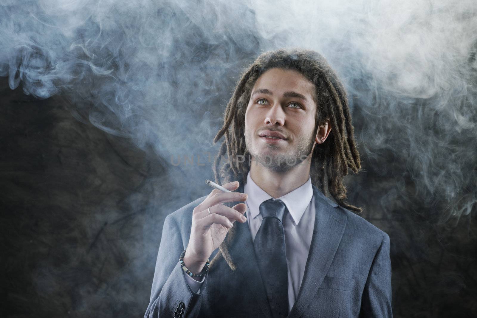 Rastafarian businessman smoking marijuana