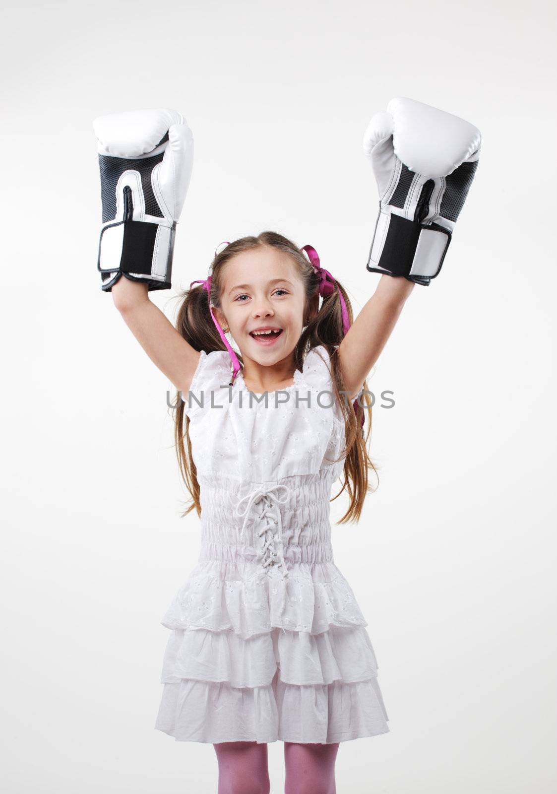 Smiling little girl wearing boxing gloves