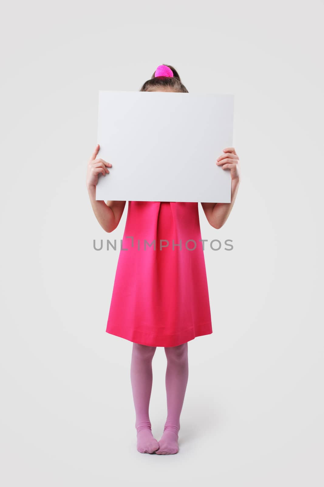 A little girl holds a blank sign, ready for your text
