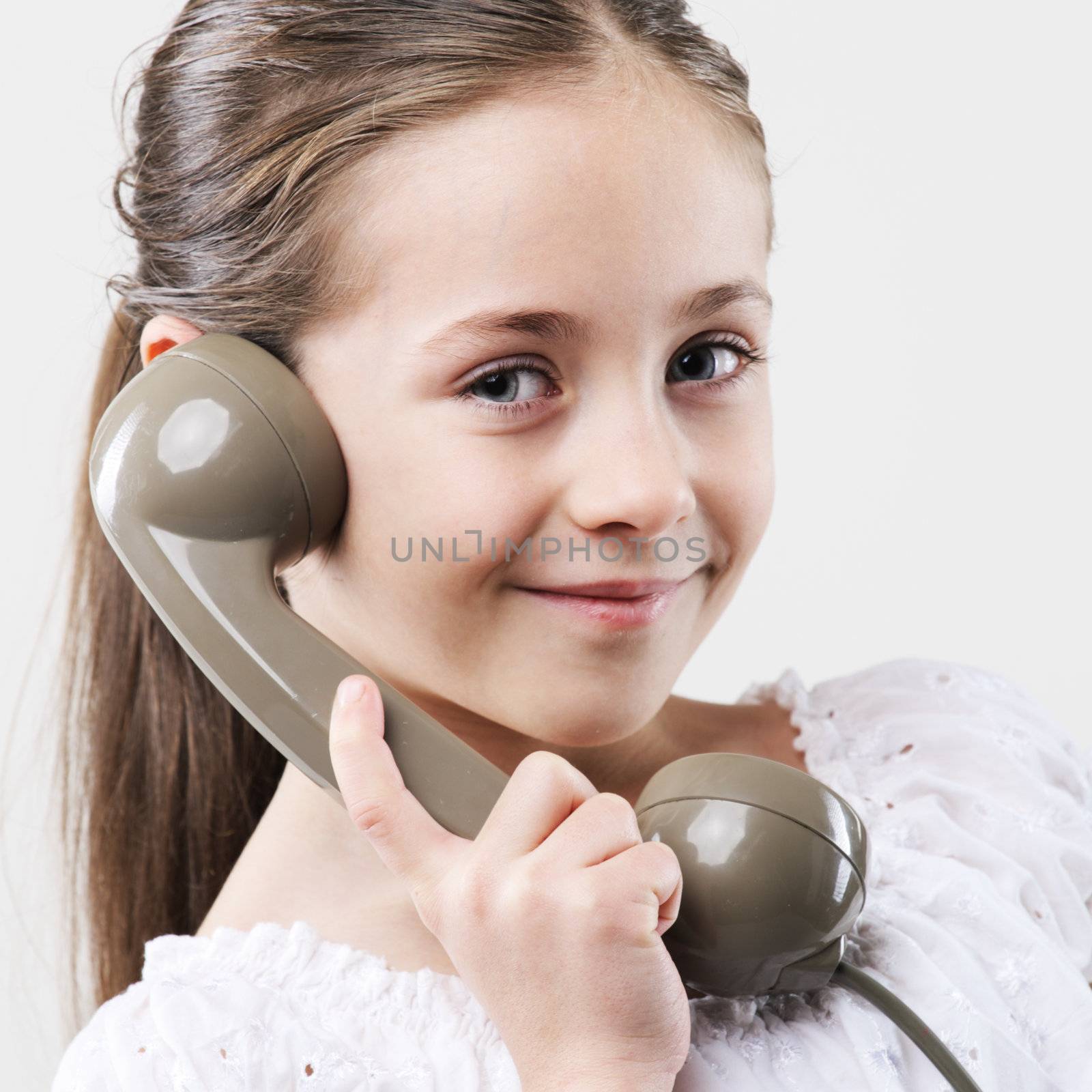 Little girl with vintage phone by stokkete