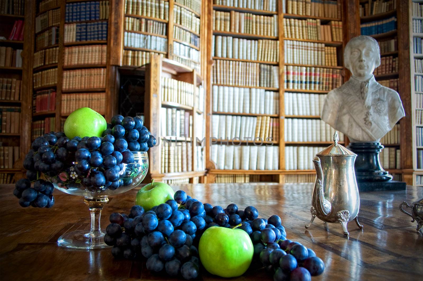 Still Life with grapes and apples in an old library