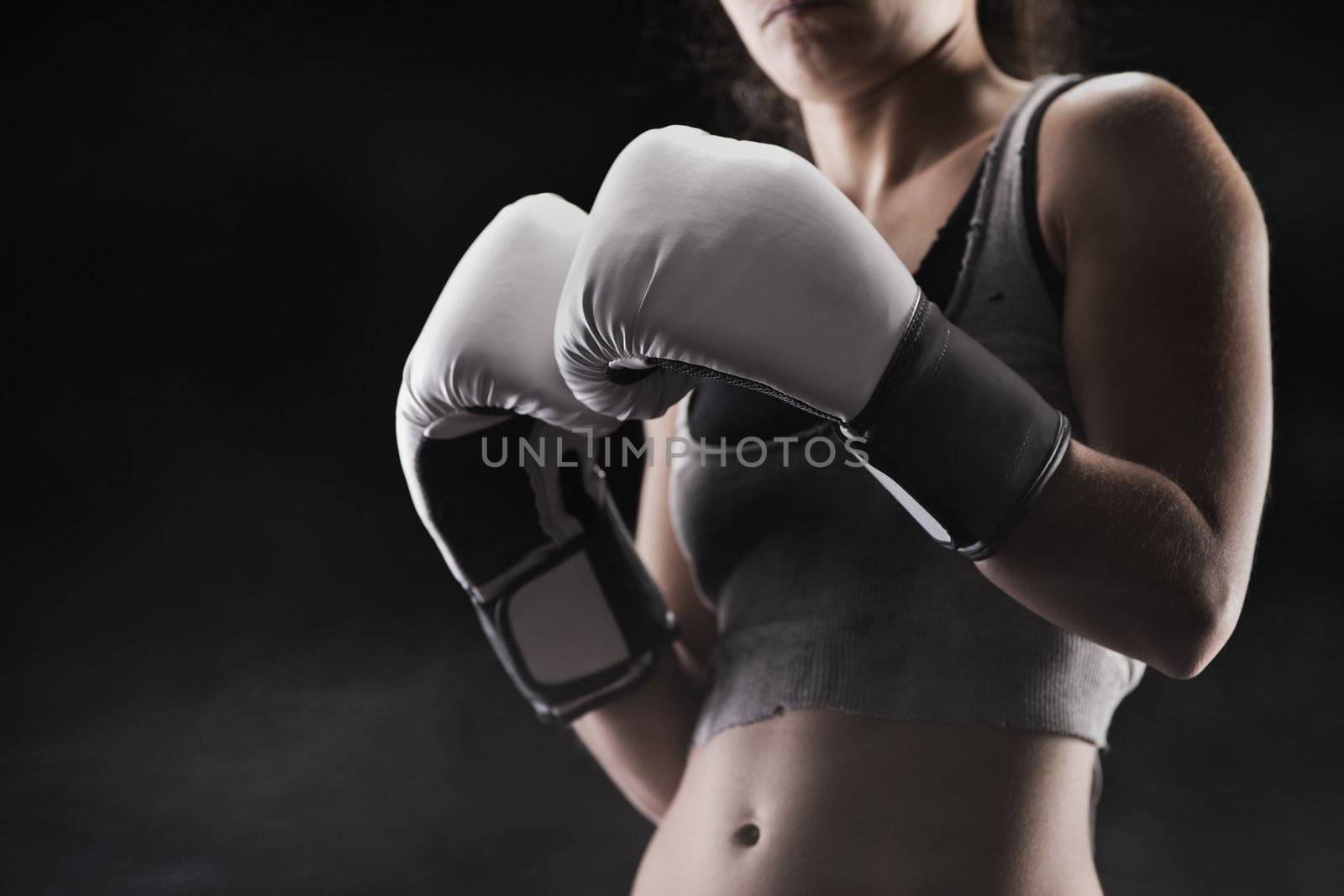 Woman boxer, focus on boxing glove, shallow deep of field