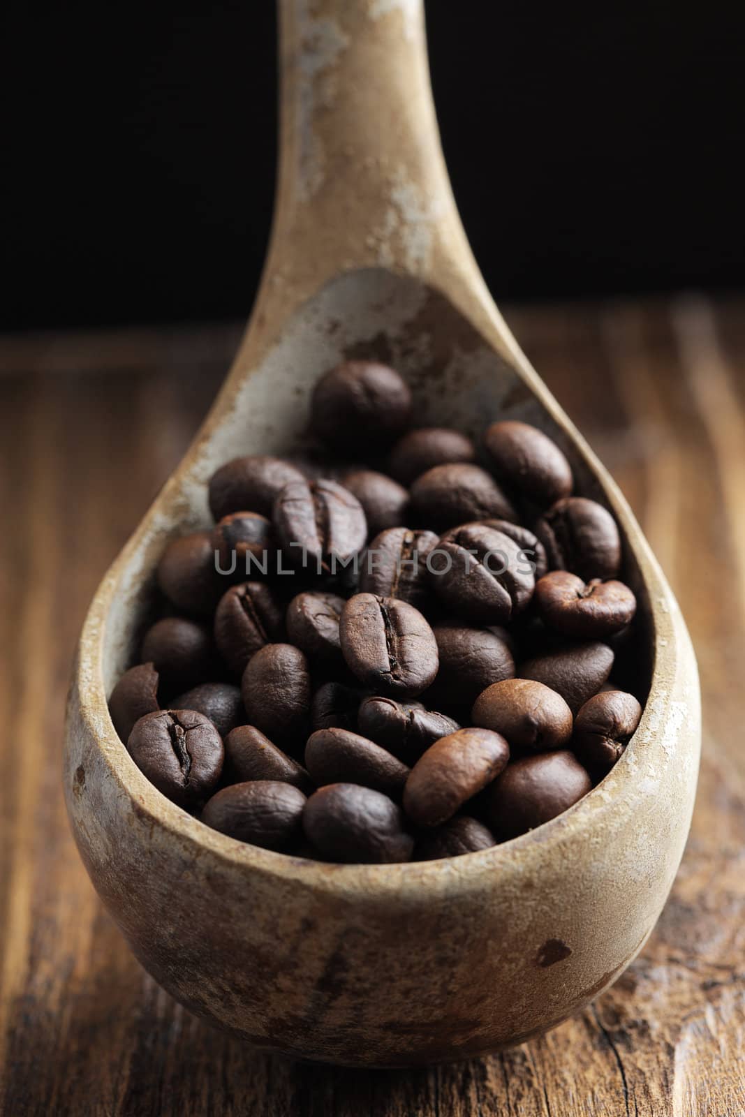 Close up of wooden spoon with coffee beans on it