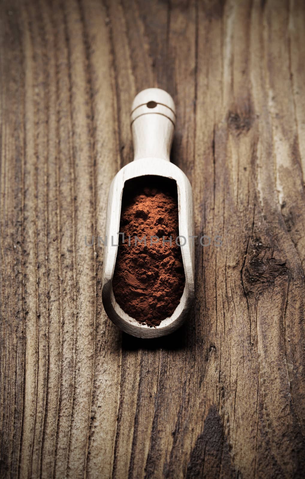 Wooden spoon full of cocoa powder, copy space