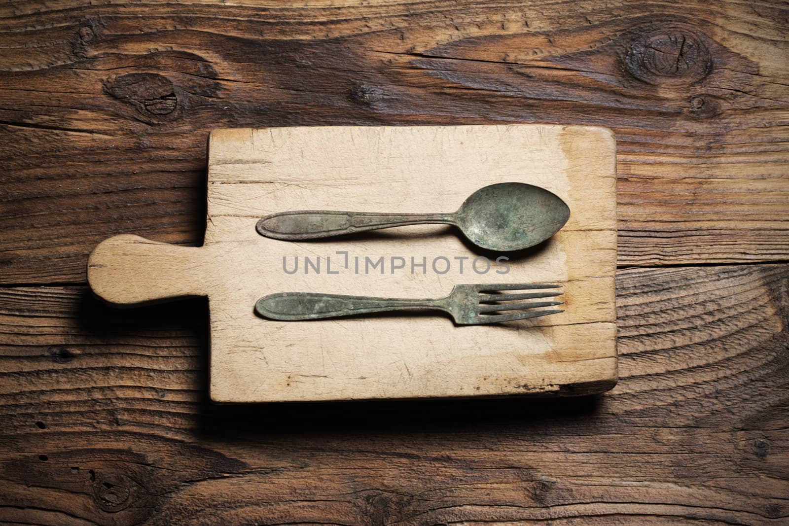 Spoon and fork, on old wood background