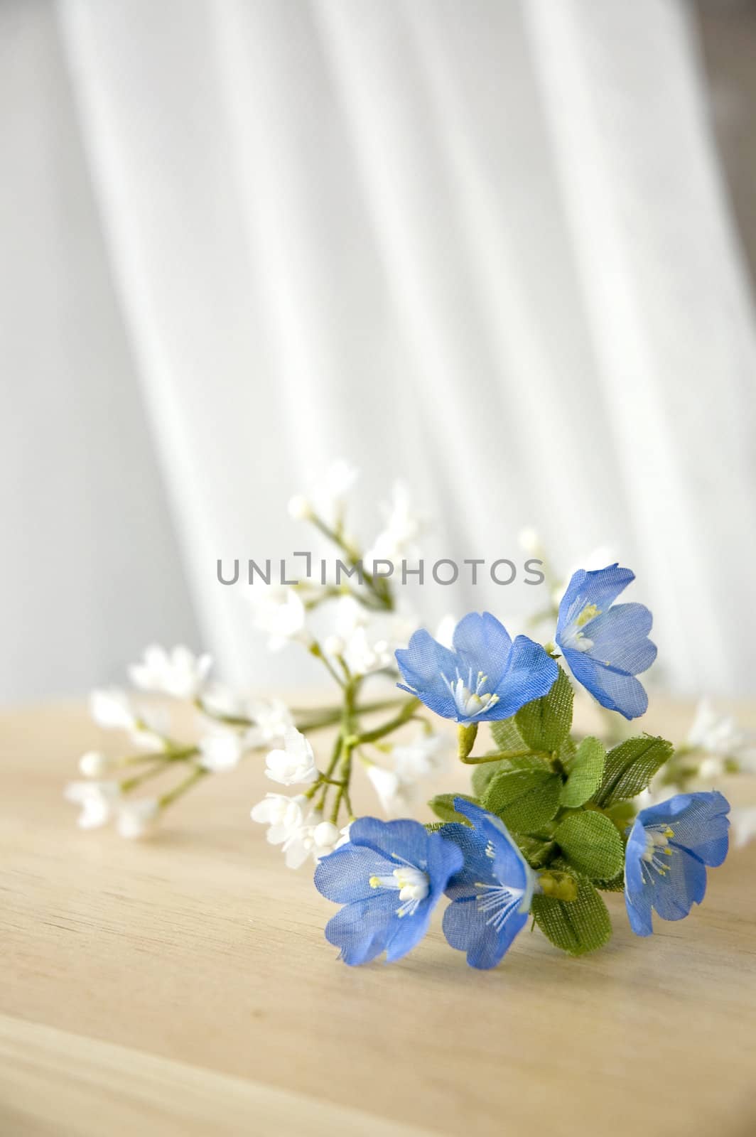 blue and white artificial flowers put on the window side