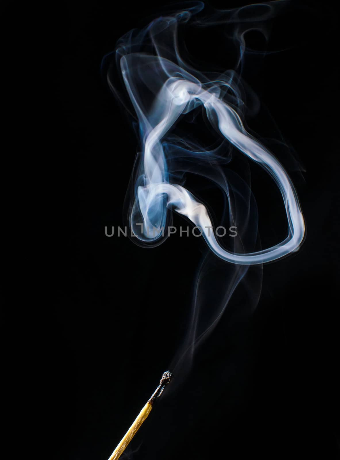 Fireless match and circle of smoke on black background